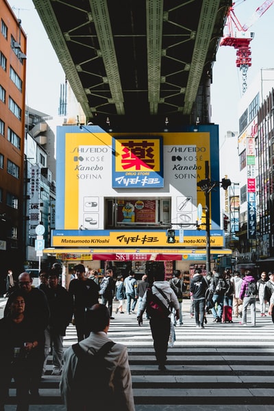 人们白天在灰色金属桥下行走